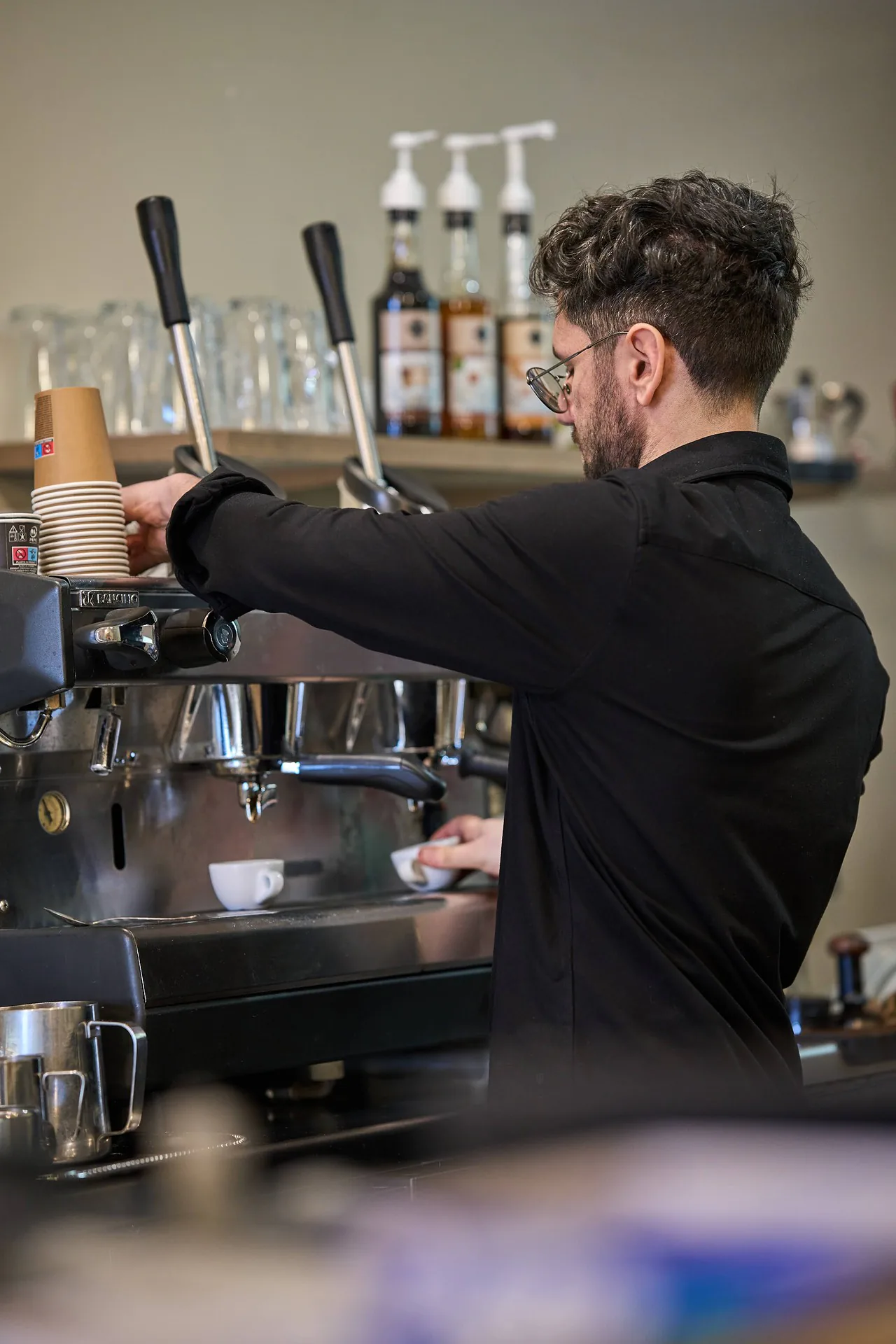 De barista aan de hendel-espressomachine van Tirrenia